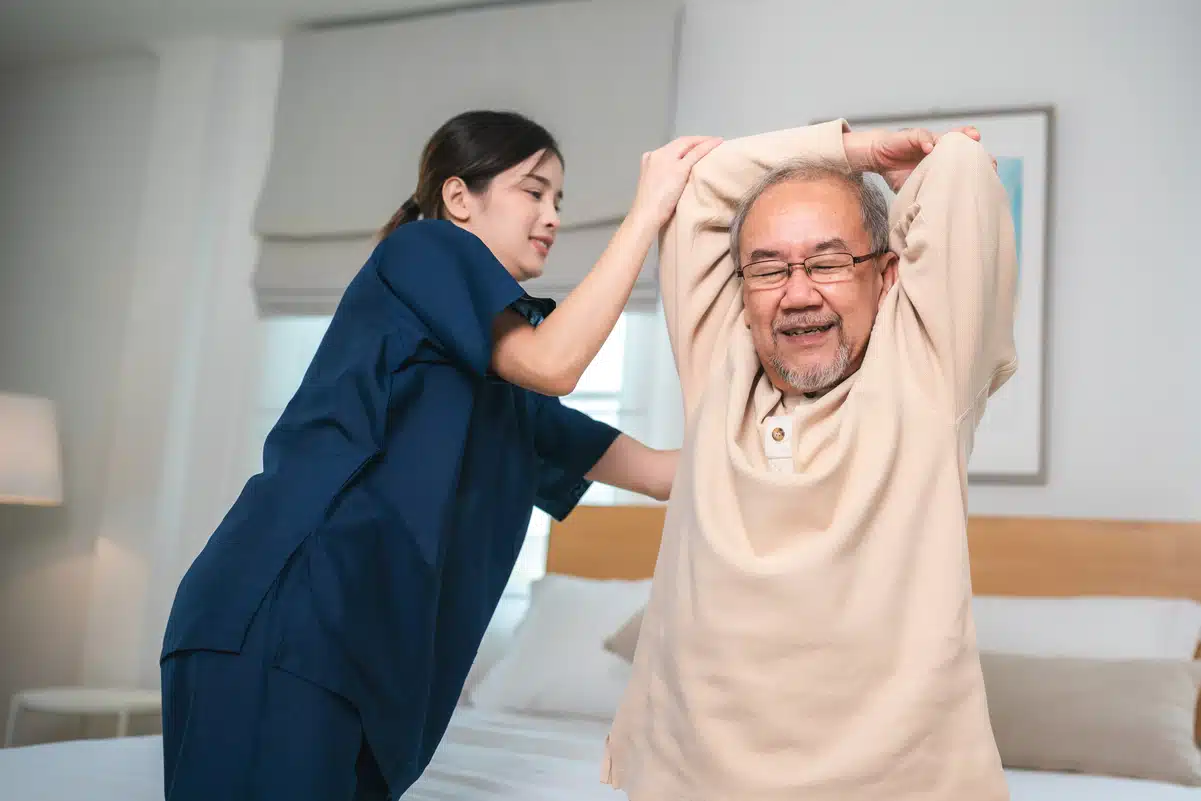 physiotherapist treating old man to some stretches